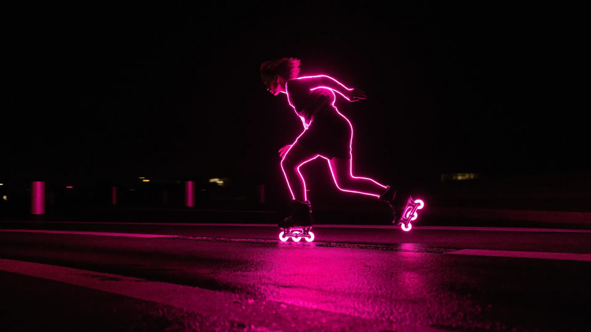 Patinadora en línea a toda velocidad de noche por las calles de Mérida, perfilada por luz de neón magenta